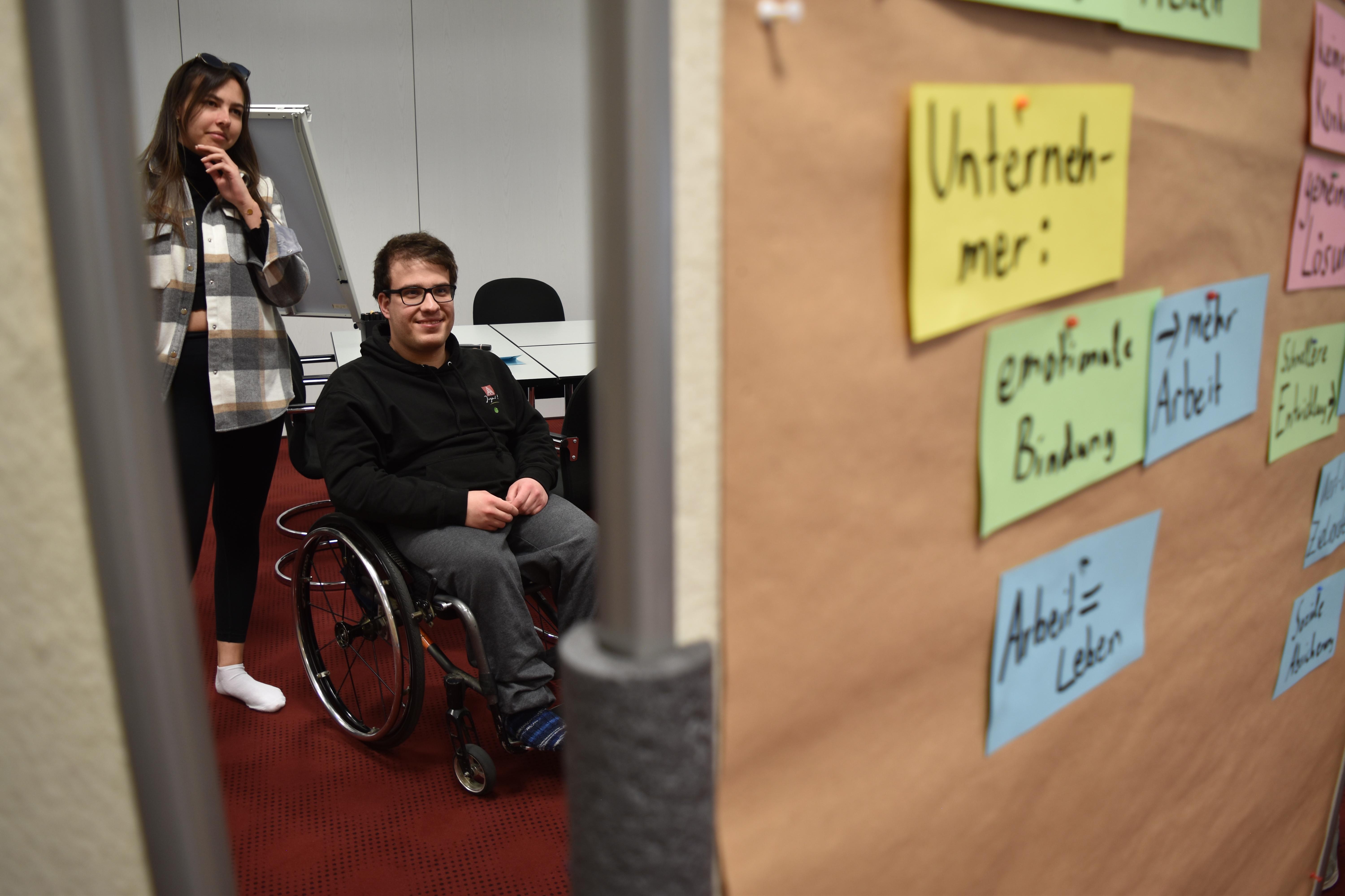Teilnehmende betrachten Pinnwand bei Jugendseminar