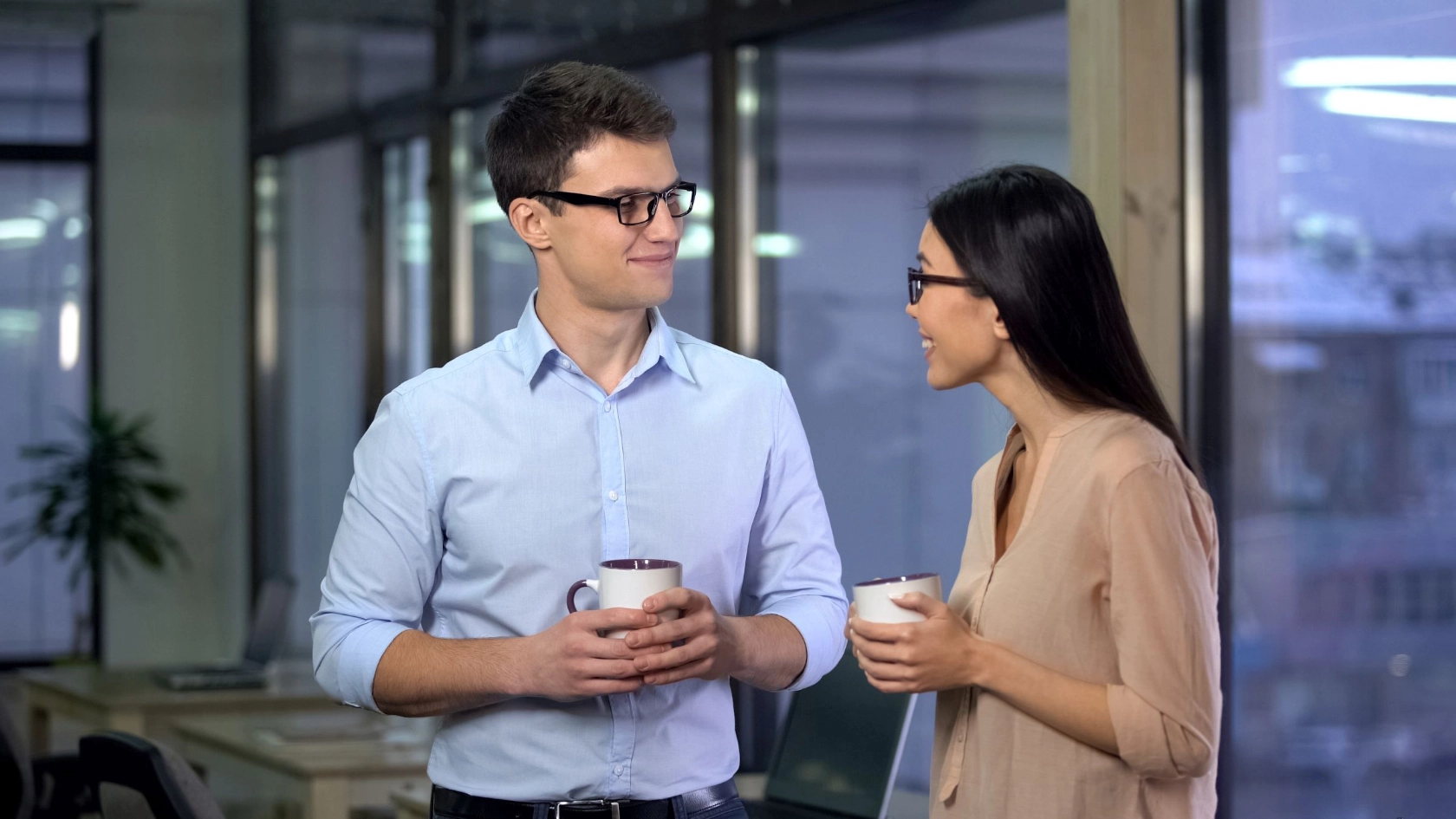 ein Mann und eine Frau unterhalten sich angeregt am Arbeitsplatz