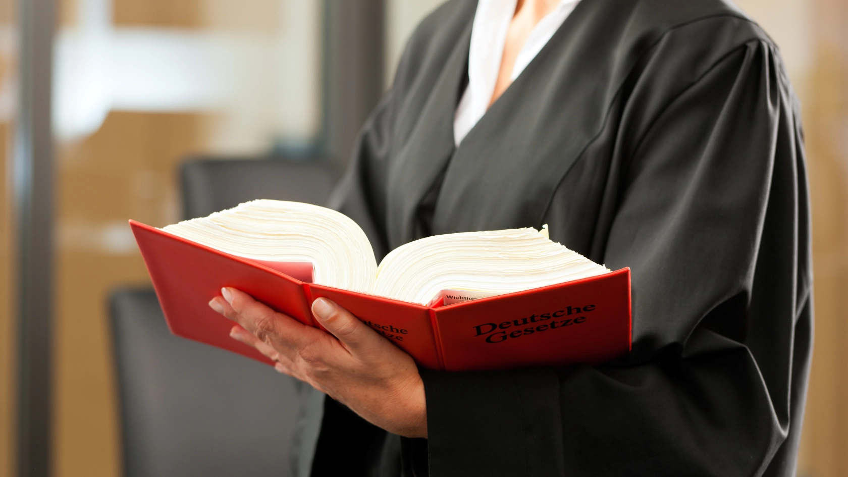 Eine Anwältin hält ein Gesetzbuch in der Hand
