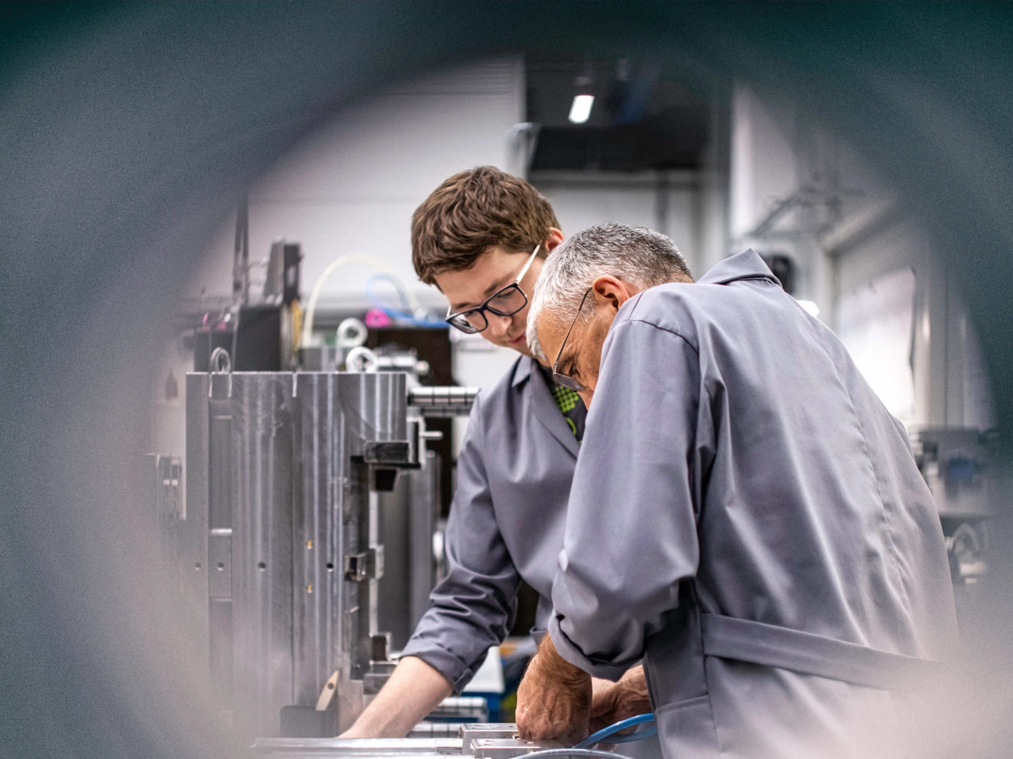 Ein älterer und ein jüngerer Arbeitnehmer in einem Betrieb.