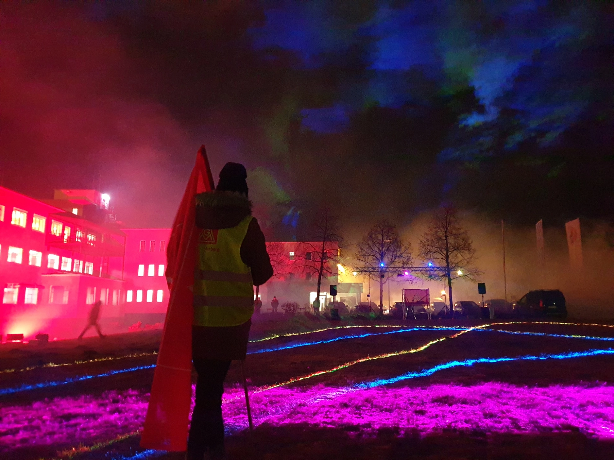 Koll. mit Fahne vor Lasershow beim Warnstreik bei Constantia in der MuE Tarirunde 2021
