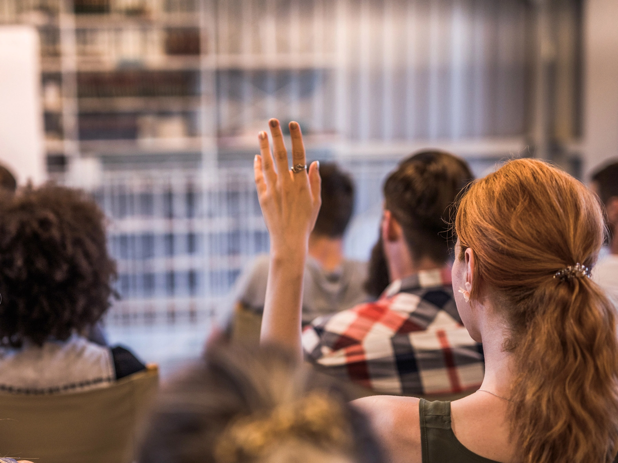 Eine Frau meldet sich während eines Seminars.