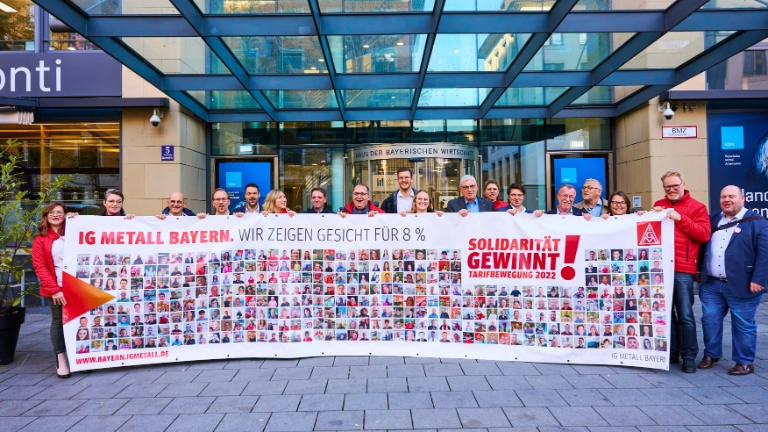 Verhandlungskommission mit Banner Fotoaktion vor vbm-Haus.