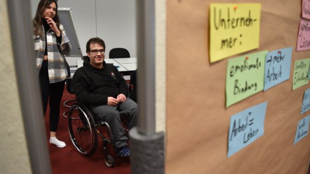 Teilnehmende betrachten Pinnwand bei Jugendseminar